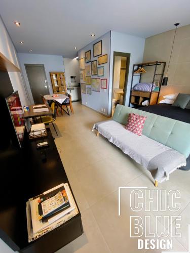 uma sala de estar com um sofá e uma cama em Chic Blue Design com Vaga de Garagem em São Paulo