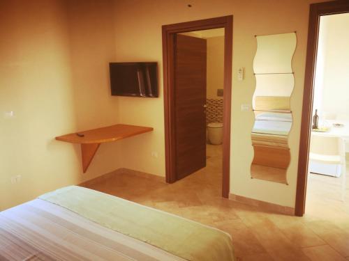 1 dormitorio con 1 cama y 1 habitación con espejo en B&b La lumaca, en Torchiarolo