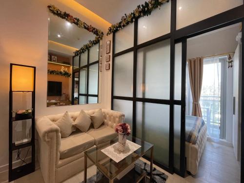 a living room with a couch and a large window at Crissome Suite Azure North San Fernando Pampanga in Lagundi