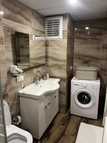 ein Badezimmer mit einer Waschmaschine und einem Waschbecken in der Unterkunft Seyir Apartmanı in Bolu