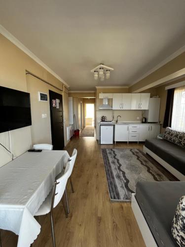 ein großes Wohnzimmer mit einem Tisch und einer Küche in der Unterkunft Seyir Apartmanı in Bolu