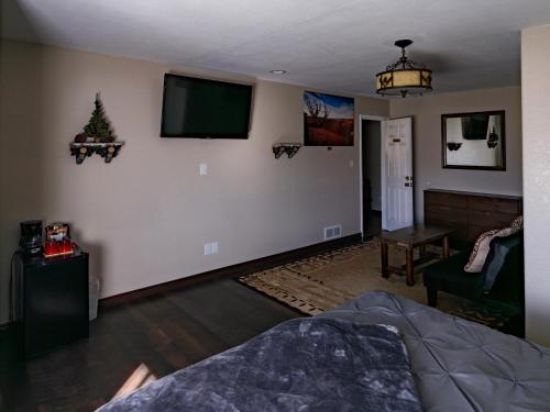 a living room with a flat screen tv on the wall at Bryce Trails Bed and Breakfast in Tropic