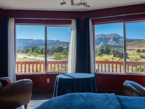 a room with windows with a table and views of mountains at Bryce Trails Bed and Breakfast in Tropic