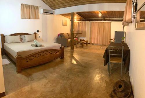 TamaHostel & Glamping في تاماريندو: غرفة نوم بسرير وطاولة في غرفة