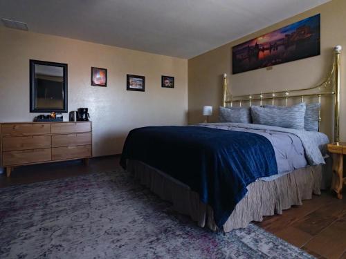 a bedroom with a bed and a dresser and a television at Bryce Trails Bed and Breakfast in Tropic