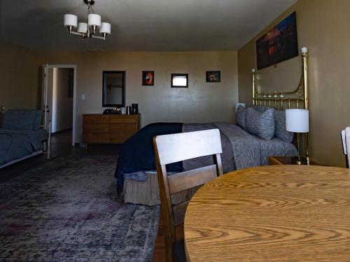 1 dormitorio con cama, mesa y sofá en Bryce Trails Bed and Breakfast, en Tropic