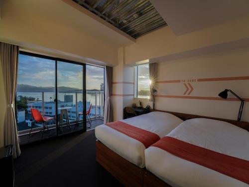 a hotel room with a bed and a large window at SETOUCHI KEIRIN HOTEL 10 by Onko Chishin in Tamano