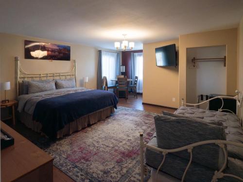 a bedroom with a bed and a couch and a tv at Bryce Trails Bed and Breakfast in Tropic