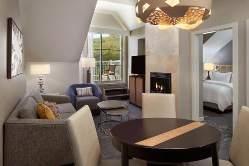 uma sala de estar com um sofá e um quarto com uma cama em The Westin Trillium House, Blue Mountain em Blue Mountains