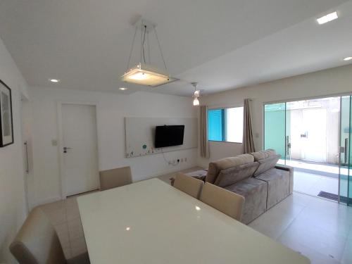 a living room with a white table and a couch at Casa Sol Nascente in Cabo Frio