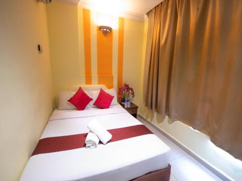 a bedroom with two beds with red and white pillows at Sun Inns Hotel Puchong Near IOI Puchong in Puchong