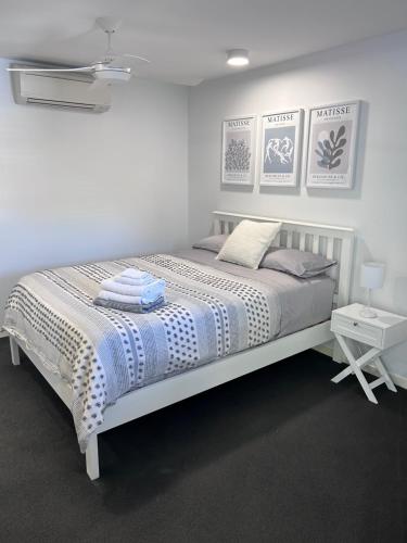 a white bed in a white room with a bed sidx sidx sidx at Unit 4 - Manly Boutique Apartments in Brisbane