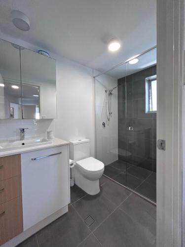 a bathroom with a toilet and a glass shower at Unit 4 - Manly Boutique Apartments in Brisbane