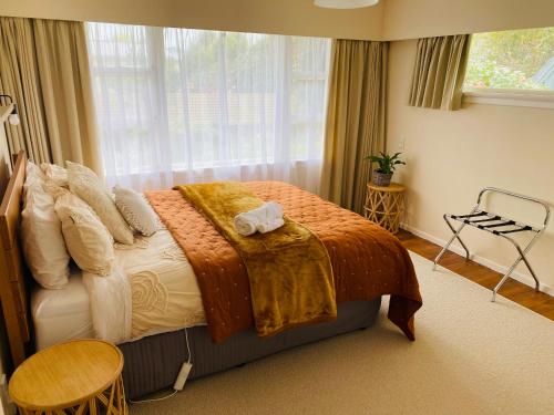 a bedroom with a bed with a blanket on it at Rosedale Retreat in Invercargill