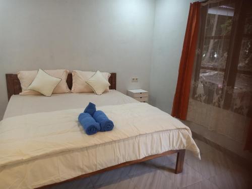 a bed with a blue stuffed animal on it at Renata Cottage in Langgur