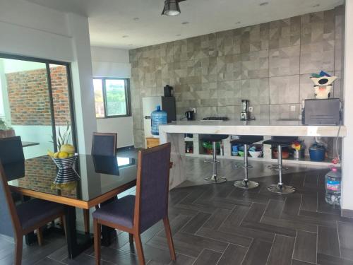 a kitchen with a counter and a table and chairs at Casa blanca Oaxtepec Tlayacapan in Oaxtepec