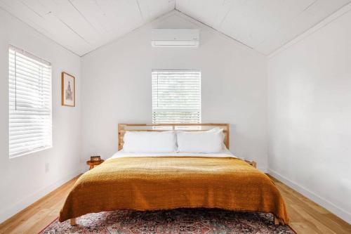 a bedroom with a bed with an orange blanket at Walk to coffee, bars, eats — The Cozy Bungalow in Austin
