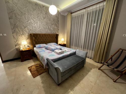 a bedroom with a bed and a large window at Villa Munjul Indah - Majalengka in Jatipamor