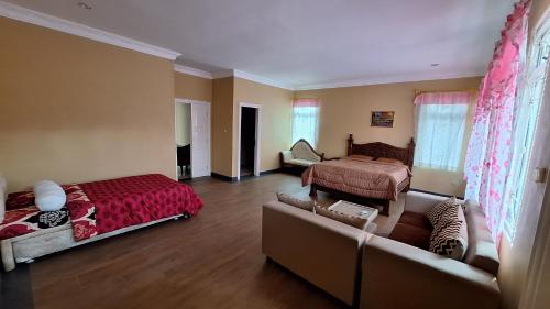 - un salon avec un lit et un canapé dans l'établissement Villa Tuscanny, à Cikundul