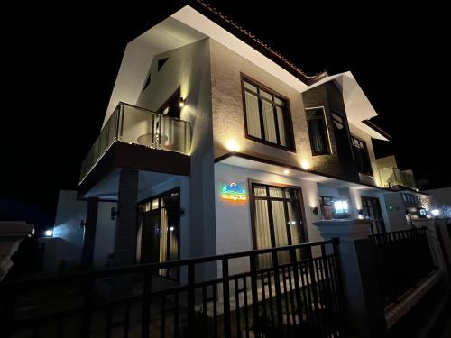 a white house with a balcony at night at Villa Munjul Indah - Majalengka in Jatipamor