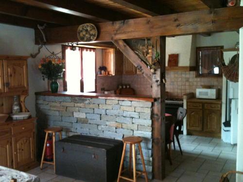 une cuisine avec une cheminée en briques et des tabourets. dans l'établissement Chalet spacieux 8 pers, 3 chambres, cheminée, Wi-Fi, BBQ - FR-1-762-1, au Monêtier-les-Bains