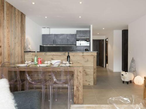 une cuisine avec une table, des chaises et un comptoir dans l'établissement Appartement rénové, skis aux pieds, 6 pers, Courchevel 1650 - Balcon sud, cosy et familial - FR-1-631-151, à Courchevel