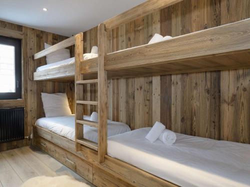 Ce lit se trouve dans un dortoir doté de 2 lits superposés et de murs en bois. dans l'établissement Appartement rénové, skis aux pieds, 6 pers, Courchevel 1650 - Balcon sud, cosy et familial - FR-1-631-151, à Courchevel