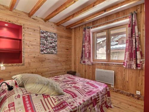 une chambre avec un lit dans une pièce en bois dans l'établissement Spacieux duplex rénové à La Plagne, proche des pistes et commerces - FR-1-455-236, à La Plagne Tarentaise
