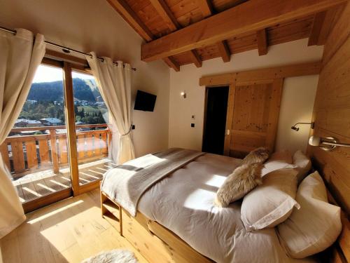 - un chat dormant sur un lit dans une chambre avec fenêtre dans l'établissement Triplex lumineux 3 chambres doubles proche centre, parking et balcon - FR-1-598-155, aux Gets