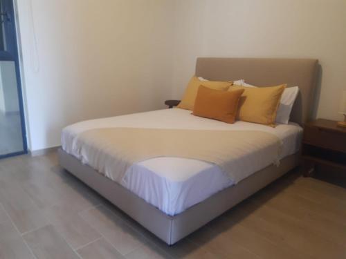 a bed with orange and white pillows in a room at RIBERA DE CHAPALA Suites in Chantepec