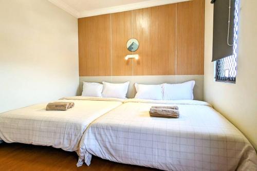 a bedroom with two beds with white sheets at Cottonwood Japandi Apartment at Majesty 1222 in Bandung