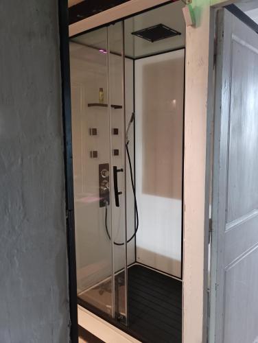 een douche met een glazen deur in een kamer bij chambre Line in Sainte-Foy-la-Grande