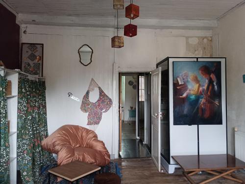 una sala de estar con sofá y una pintura en la pared en chambre Line, en Sainte-Foy-la-Grande