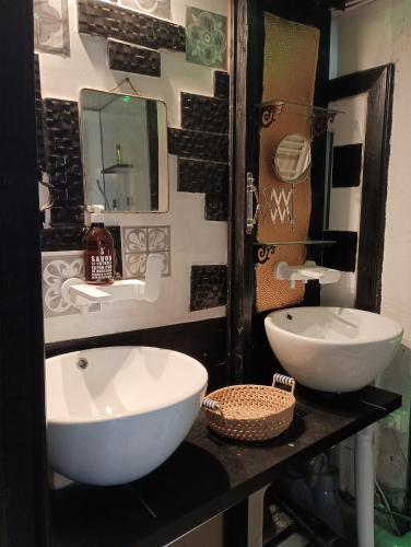 ein Badezimmer mit zwei weißen Waschbecken und einem Spiegel in der Unterkunft chambre Line in Sainte-Foy-la-Grande