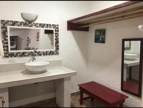 W łazience znajduje się umywalka i lustro. w obiekcie Rural cotage and sandy bay w mieście Tela
