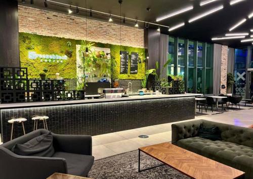 a lobby with a bar with plants on the wall at Ocean View Downtown Apt on 23rd Floor with Balcony, Rooftop Pool, Kitchen, Gym, & Restaurants in Miami