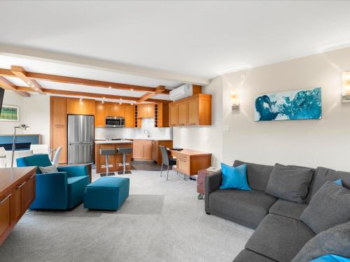 a living room with a couch and a kitchen at Ski In/Out, Steam Shower, Pool, Hot Tub, Sauna in Whistler