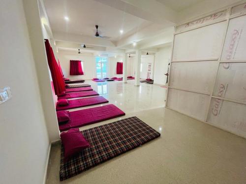 a large room with red chairs and a carpet at Gaurav guest house in Bodh Gaya