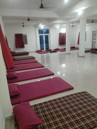 a room with rows of red mats on the floor at Gaurav guest house in Bodh Gaya