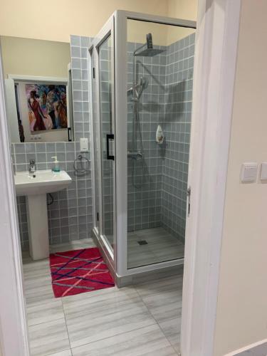 uma casa de banho com um chuveiro e um lavatório. em Luxury for you em Acra