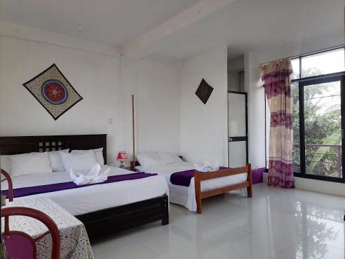 a bedroom with two beds and a window at Chimicuas House in Puerto Maldonado