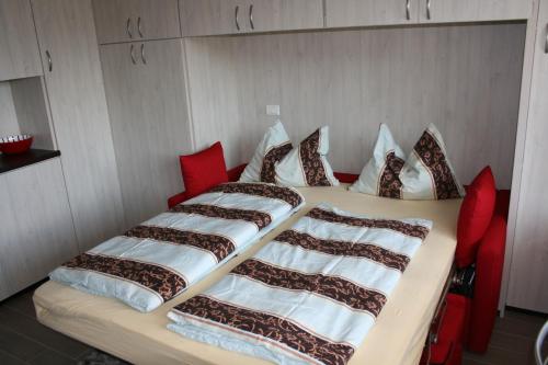 two beds in a room with red chairs at Apartment Imma in Tremosine Sul Garda