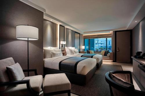 クアラルンプールにあるJW Marriott Kuala Lumpurのベッド2台とソファが備わるホテルルームです。