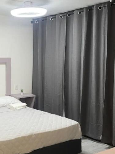 a bedroom with a bed and a gray curtain at Hotel PM Polanco in Mexico City