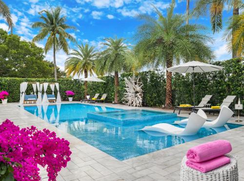 a swimming pool with white chairs and palm trees at MIA MANSION W/ POOL / BBQ /CABANNA / OUTDOOR BAR in Tamiami