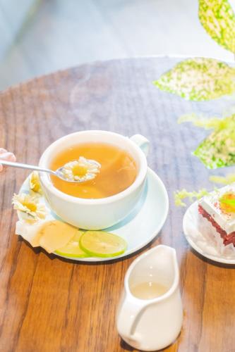 a cup of tea on a table with a piece of cake at Seahorse Han Market Da Nang Apartment by Haviland in Danang