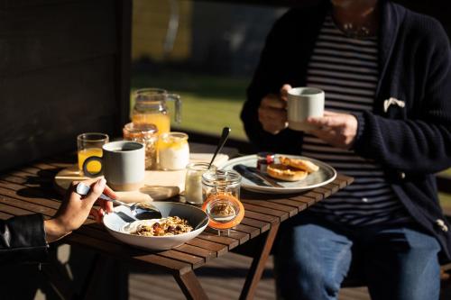 two people sitting at a table with food and drinks at Hermitage Lodge in Pokolbin