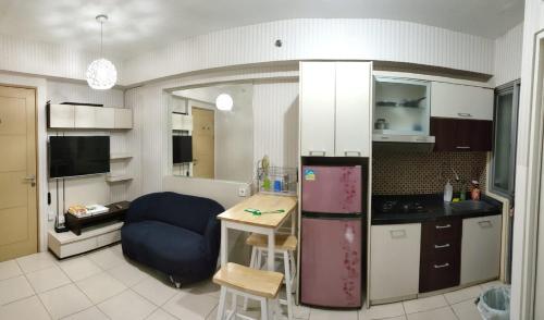 eine Küche mit einem Kühlschrank und einem Tisch darin in der Unterkunft Apartemen Pakuwon Educity yale in Surabaya