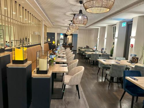 a long row of tables and chairs in a restaurant at Hotel Schöne Aussicht in Wilhelmshaven
