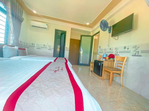 a bedroom with a large bed with a red and white blanket at KHÁCH SẠN HƯNG THỊNH - Lý Sơn in Ly Son